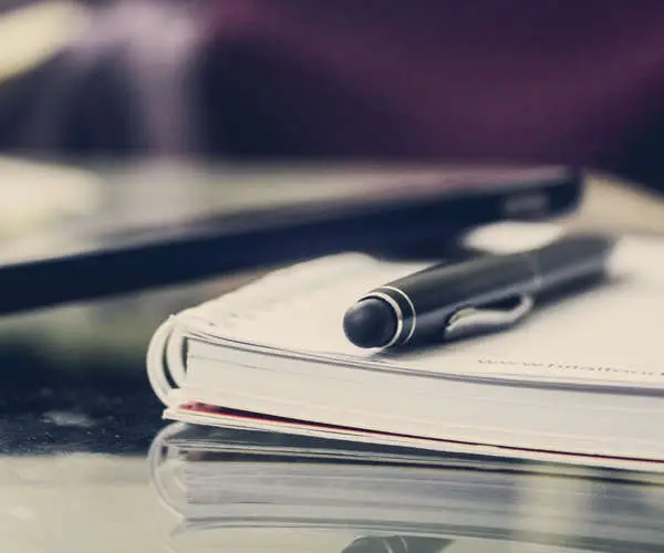 A pen and phone on top of a diary