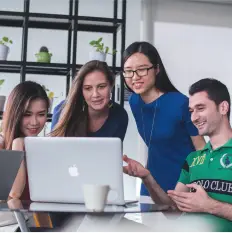 4 people around a macbook