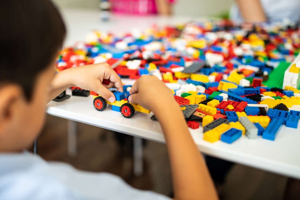 child playing with lego and toy car