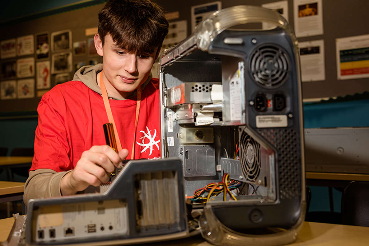 A student working on an open PC tower