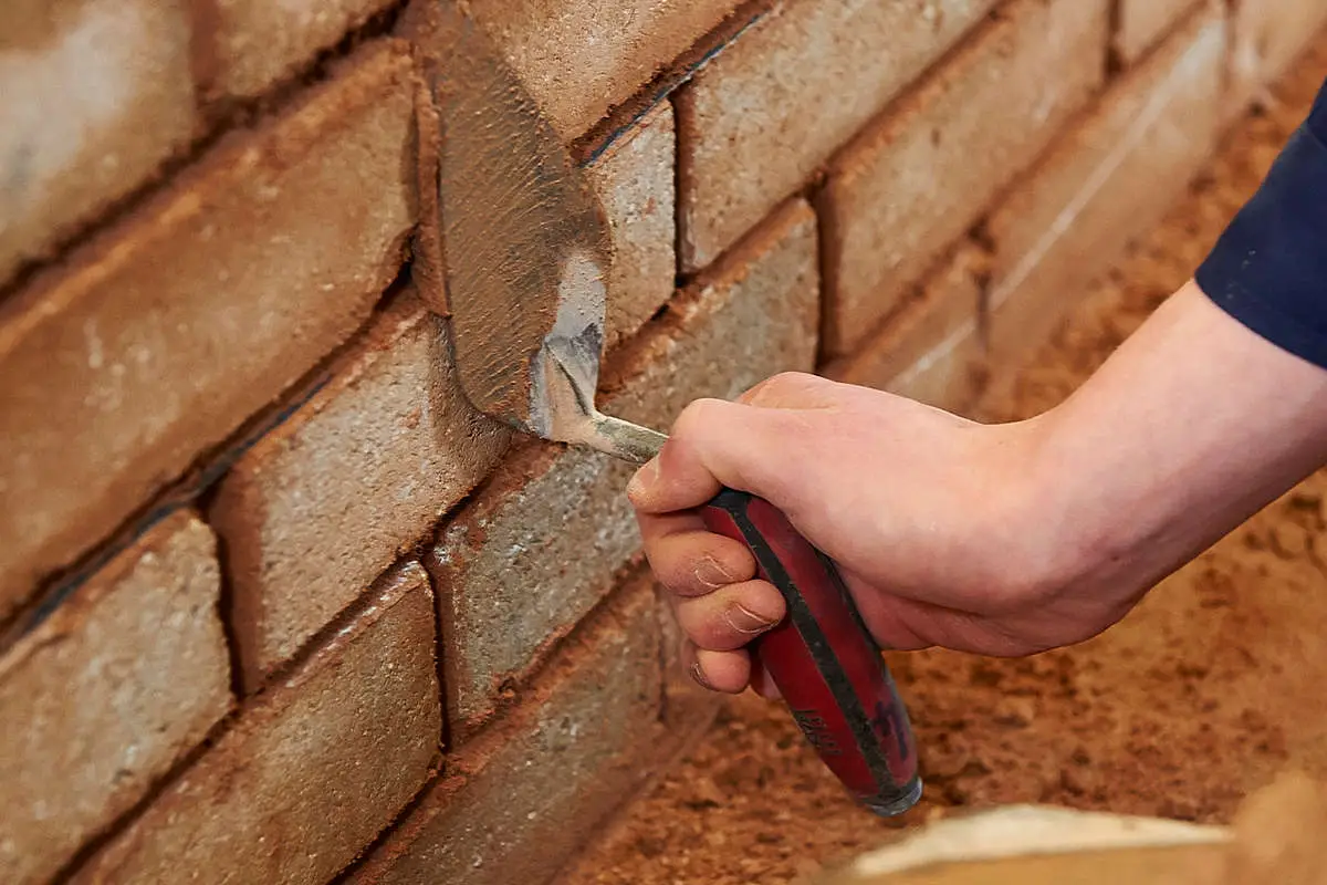 bricks being pointed with mortar using a trowel