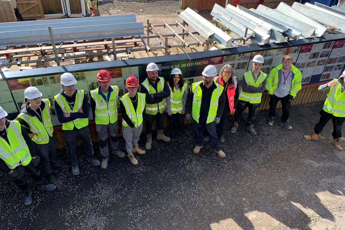 a group pose in PPE outside a construction site