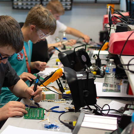 A group of students soldering PCBs