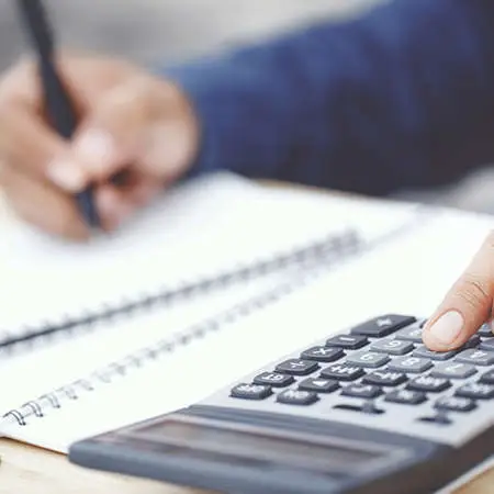 A male working out maths problems on a calculator