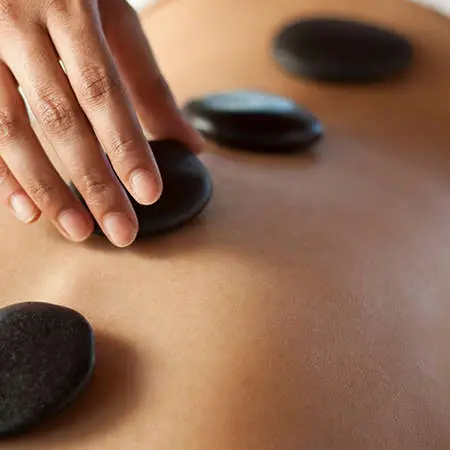 Stones being placed on someones bare back