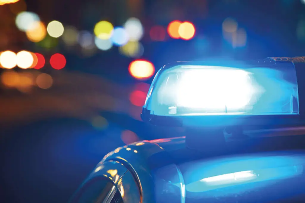 A flashing light on top off an emergency service car at night.