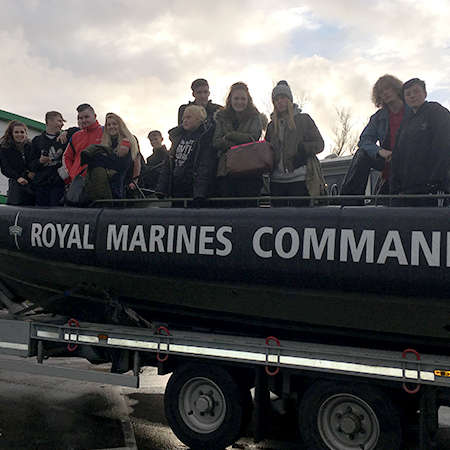 A group of students on land on a Royal Marines boat