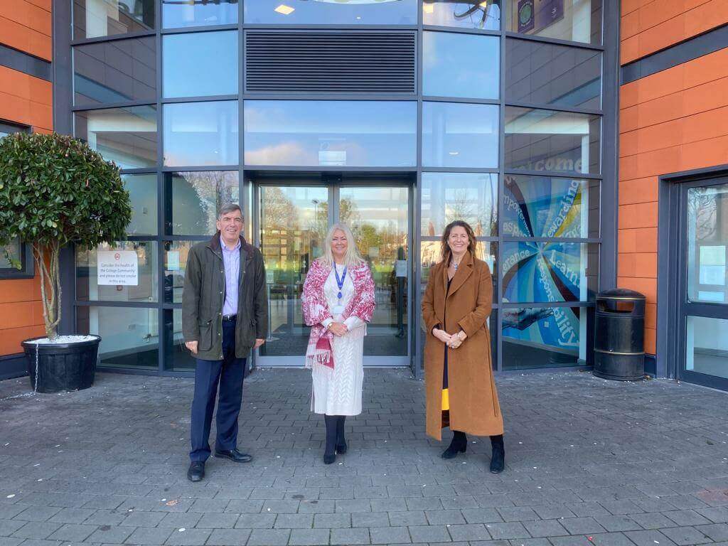 3 people pose outside of the Macclesfield College entrance