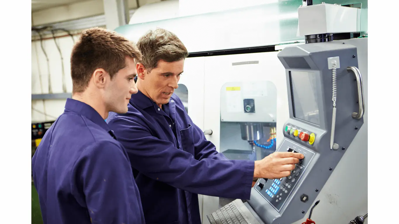 An engineer and an apprentice looking at machinery