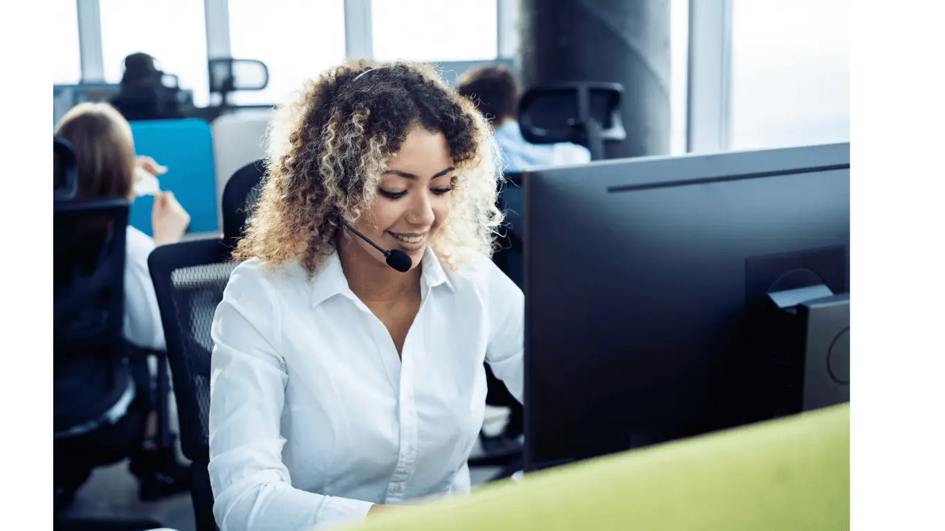 A customer service assistant apprentice at work in an office chatting on the phone