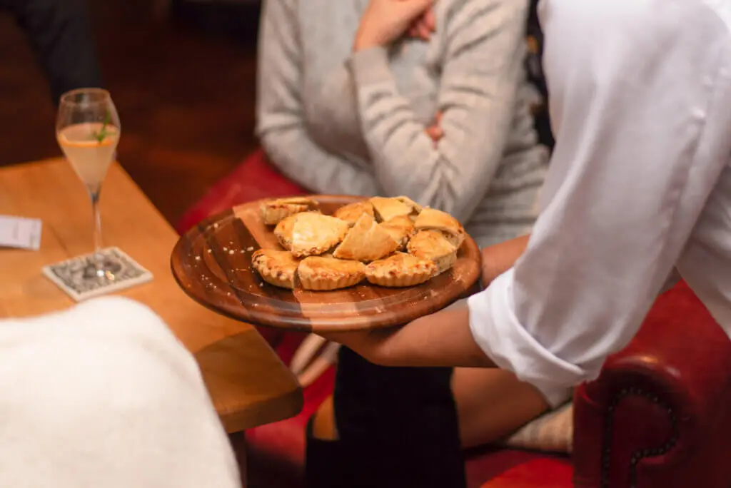 A whites chef academy student is serving food to a group of people during an event