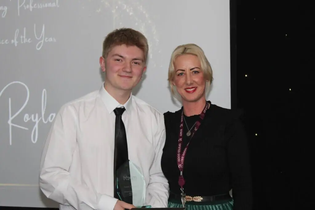 A student and a teacher smiling for a photograph during Macclesfield College's Apprenticeship Awards ceremony.