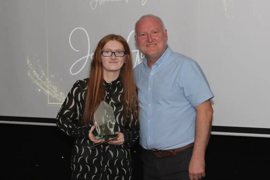 A student and a teacher smiling for a photograph during Macclesfield College's Apprenticeship Awards ceremony.