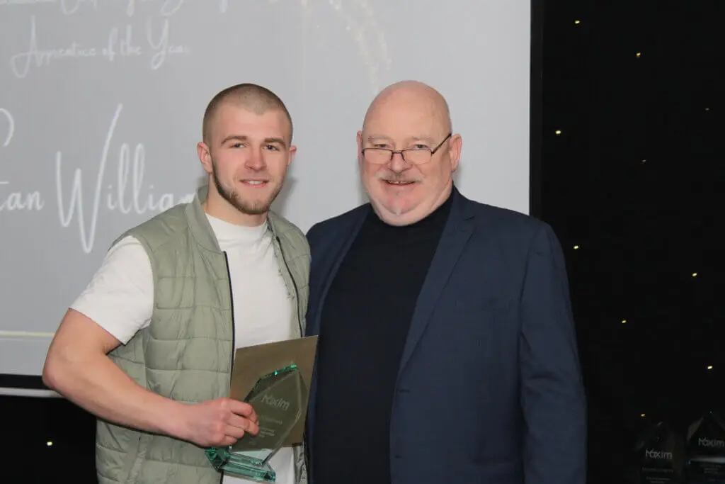 A student and a staff member smiling for a photograph during Macclesfield College's Apprenticeship Awards ceremony.