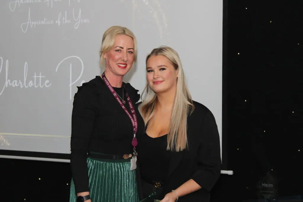 A student and a staff member smiling for a photograph during Macclesfield College's Apprenticeship Awards ceremony.
