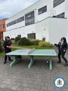 Two students playing table tennis outside