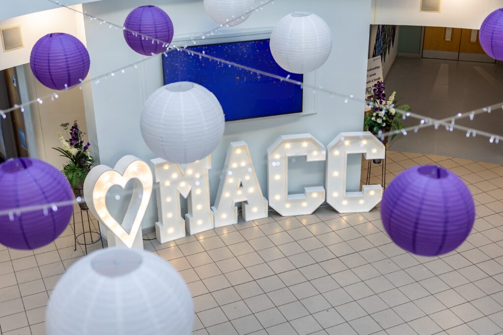 An illuminated heart with the letters “MACC” are placed neatly