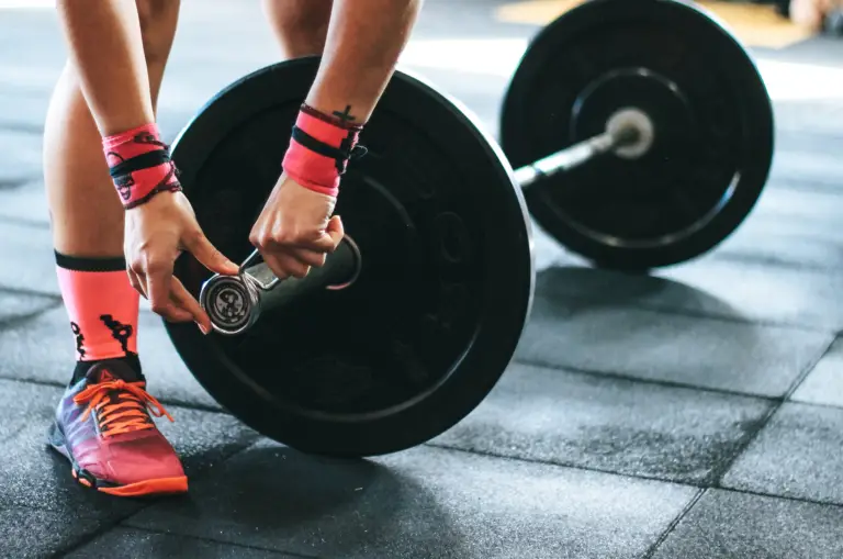 A person is adjusting gym weights.