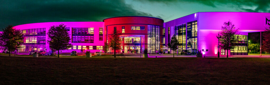 Macclesfield College is brightly lit up at night during a college open event