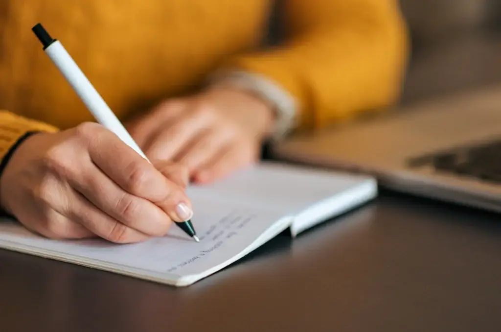 Someone writing in a notebook.