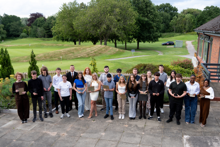 A photo from Macclesfield College's Student Awards. A group of students are holding awards and smiling for a photo.