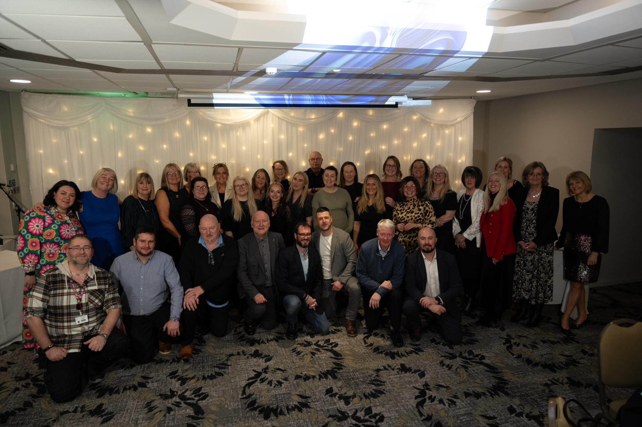 A photo from Macclesfield College's apprenticeship awards of a group of people smiling for a photo