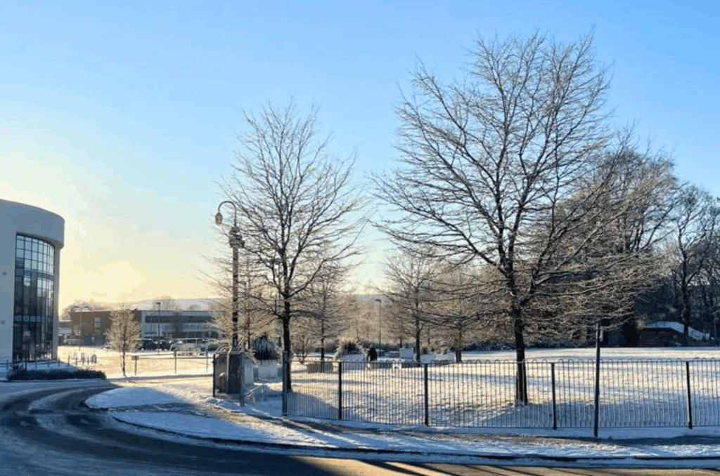 The image shows Macclesfield College in the snow on a bright day.