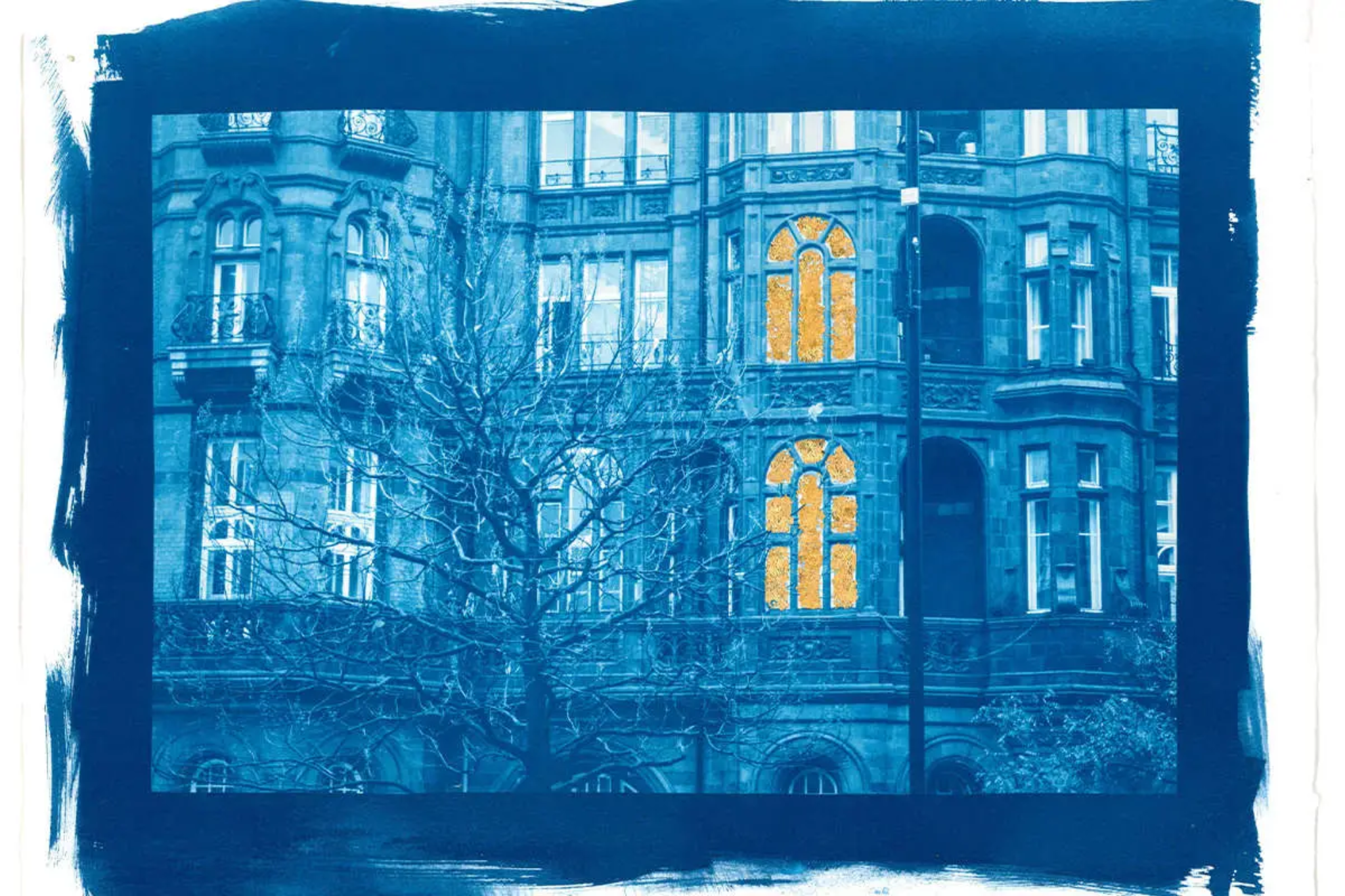 A blue image of the front of an old building. Two of the large arched widows on the building have been painted yellow.