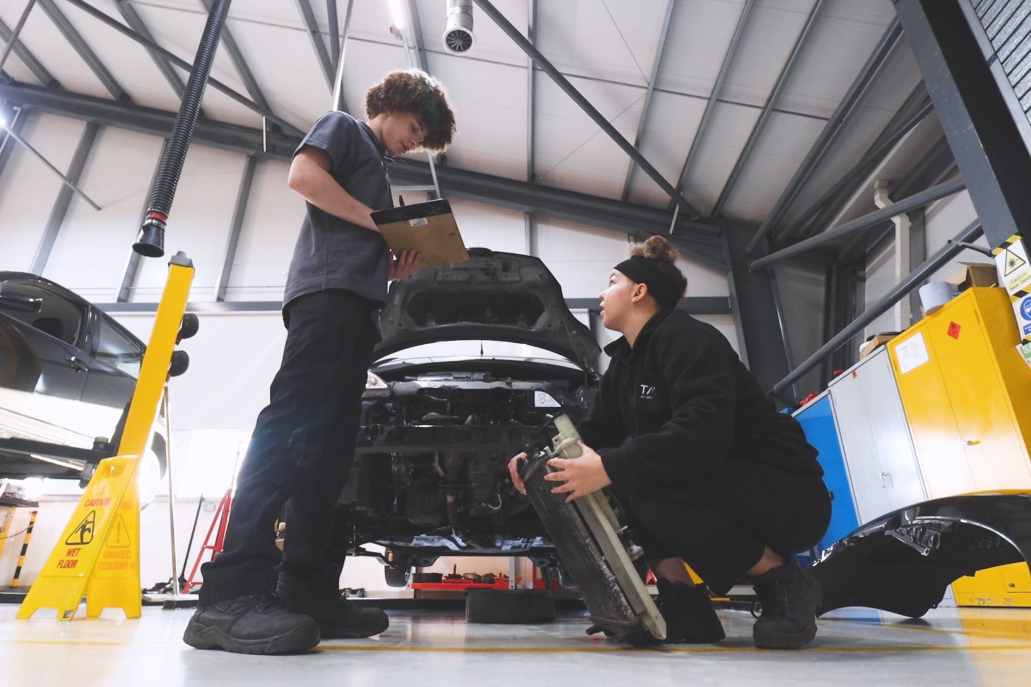 Two Automotive students doing checks on a vehicle