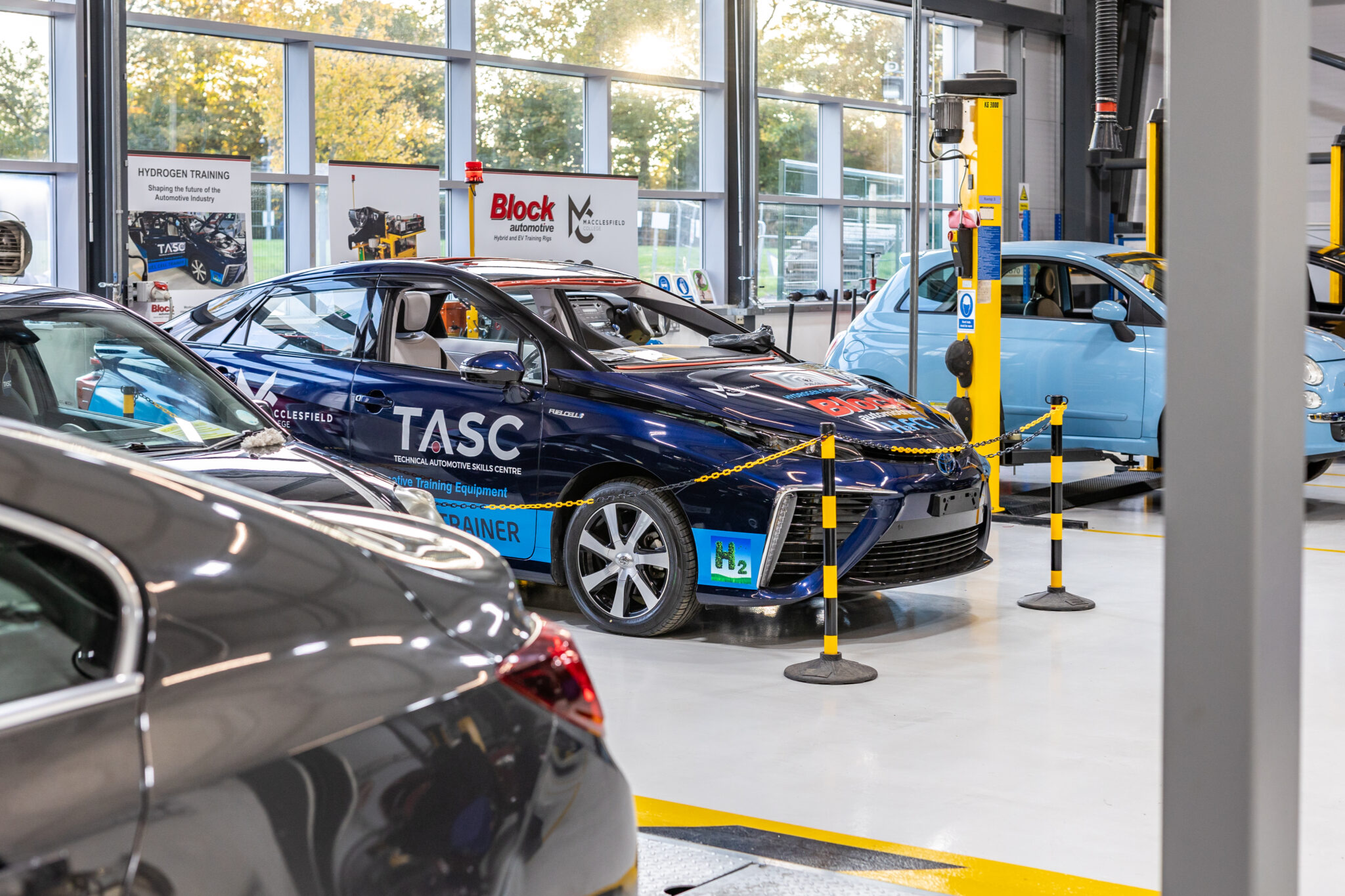 Three cars inside of Macclesfield College's Automotive workshop
