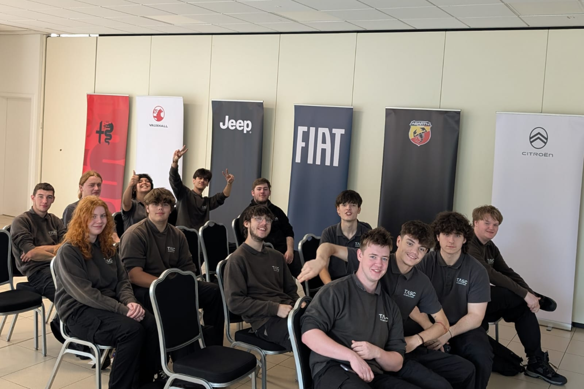 A group photo of Automotive students smiling for a photo during a trip.