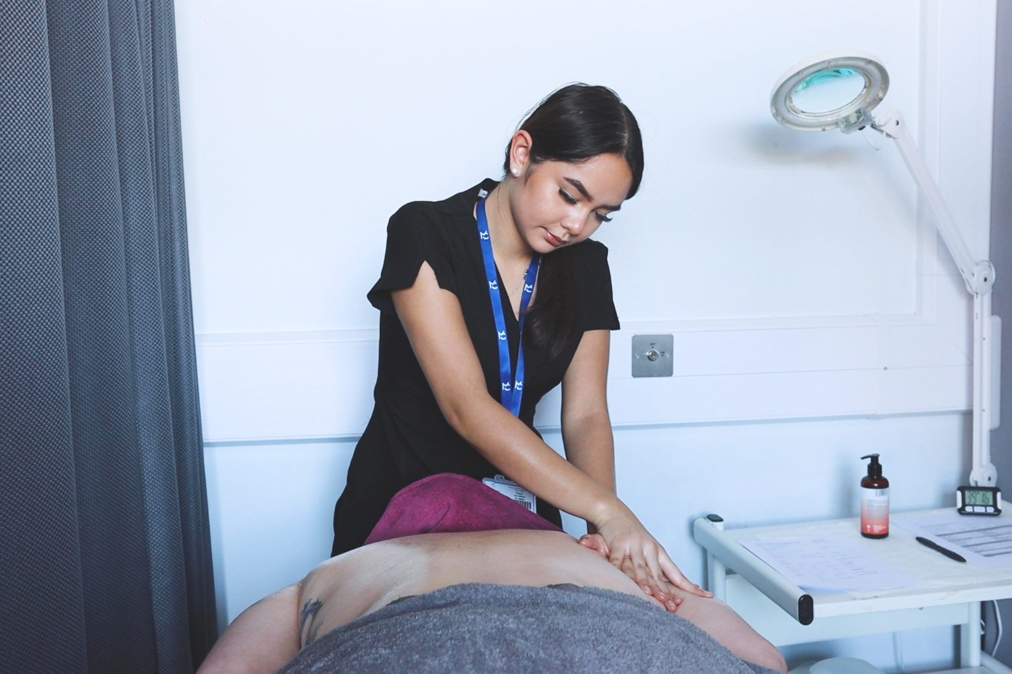 A beauty student performs a massage on a client