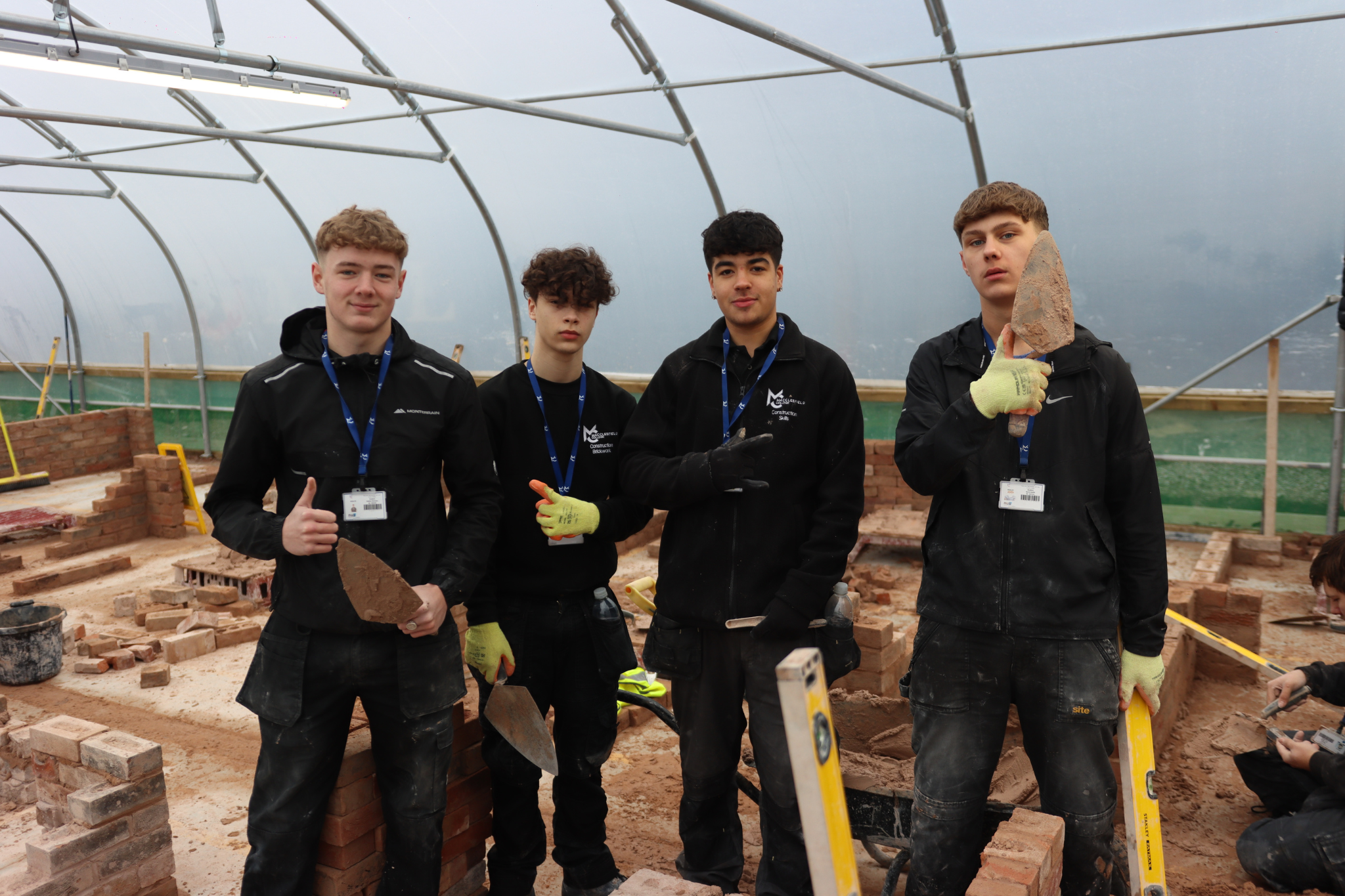 A group of bricklaying students smiling for a photo