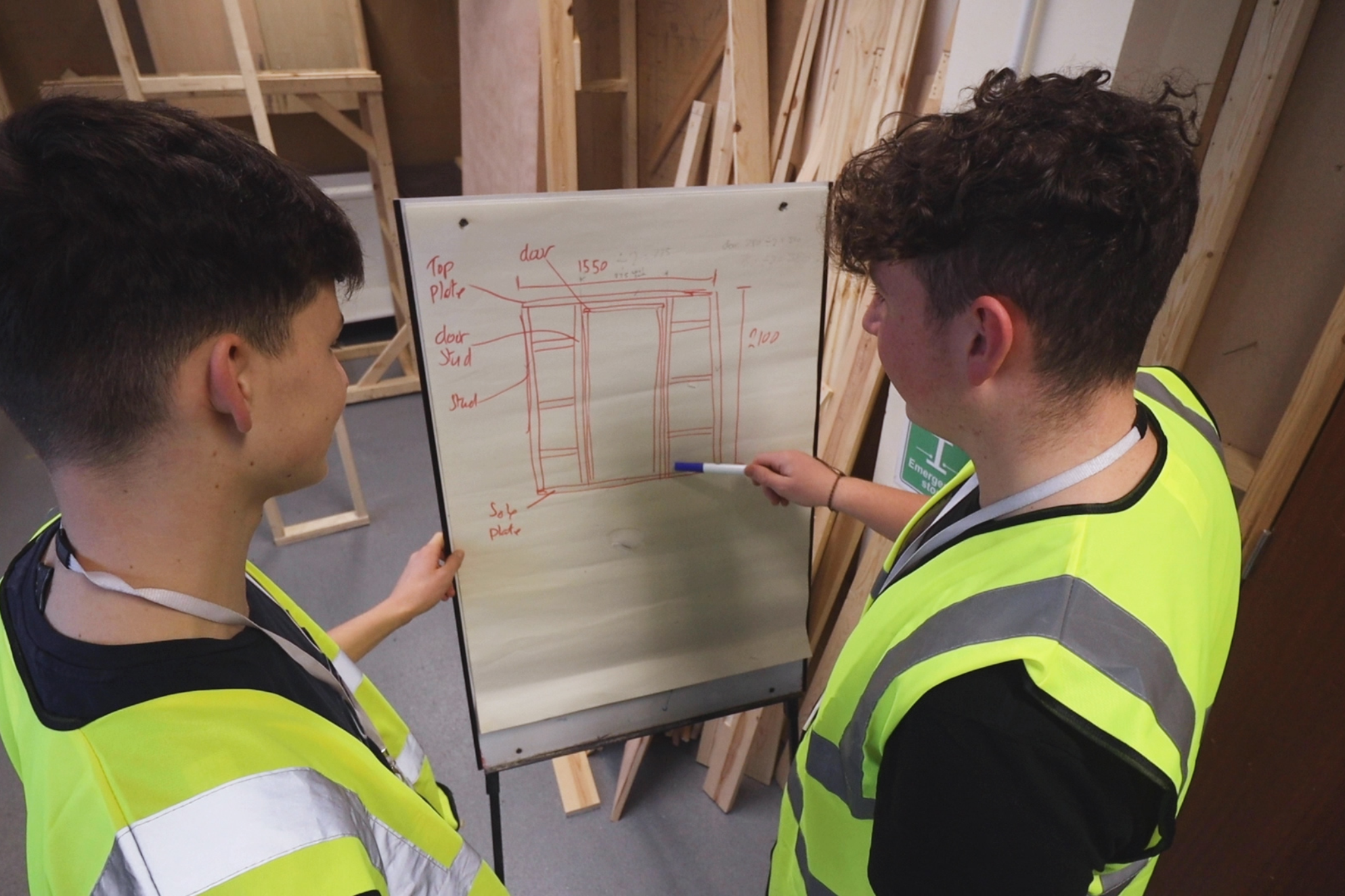 Two Carpentry and Joinery students are looking at a drawing.
