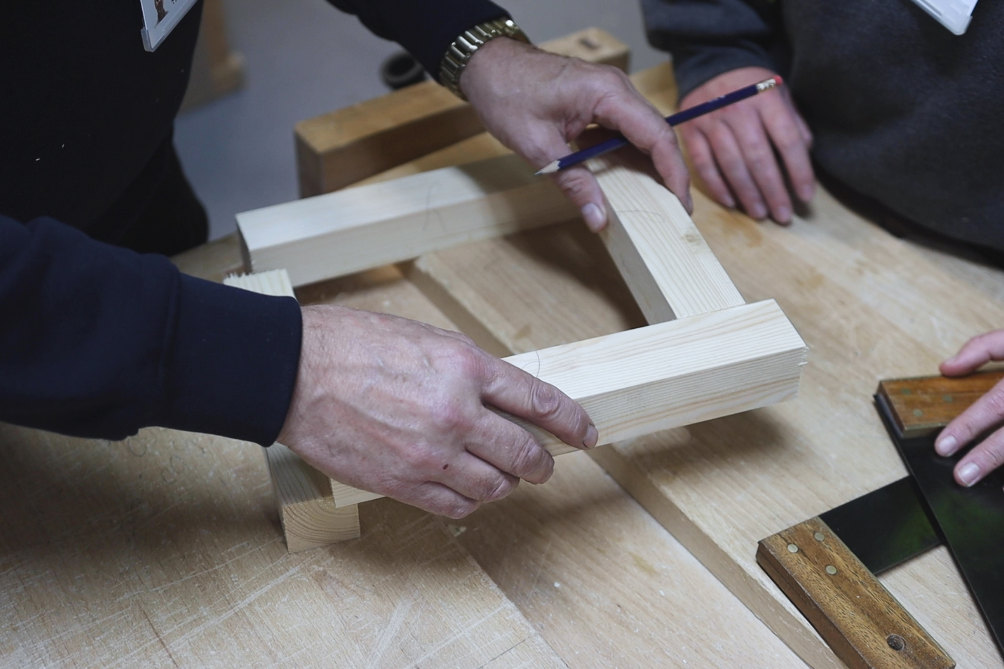 Carpentry and joinery students are placing piece of wood together.