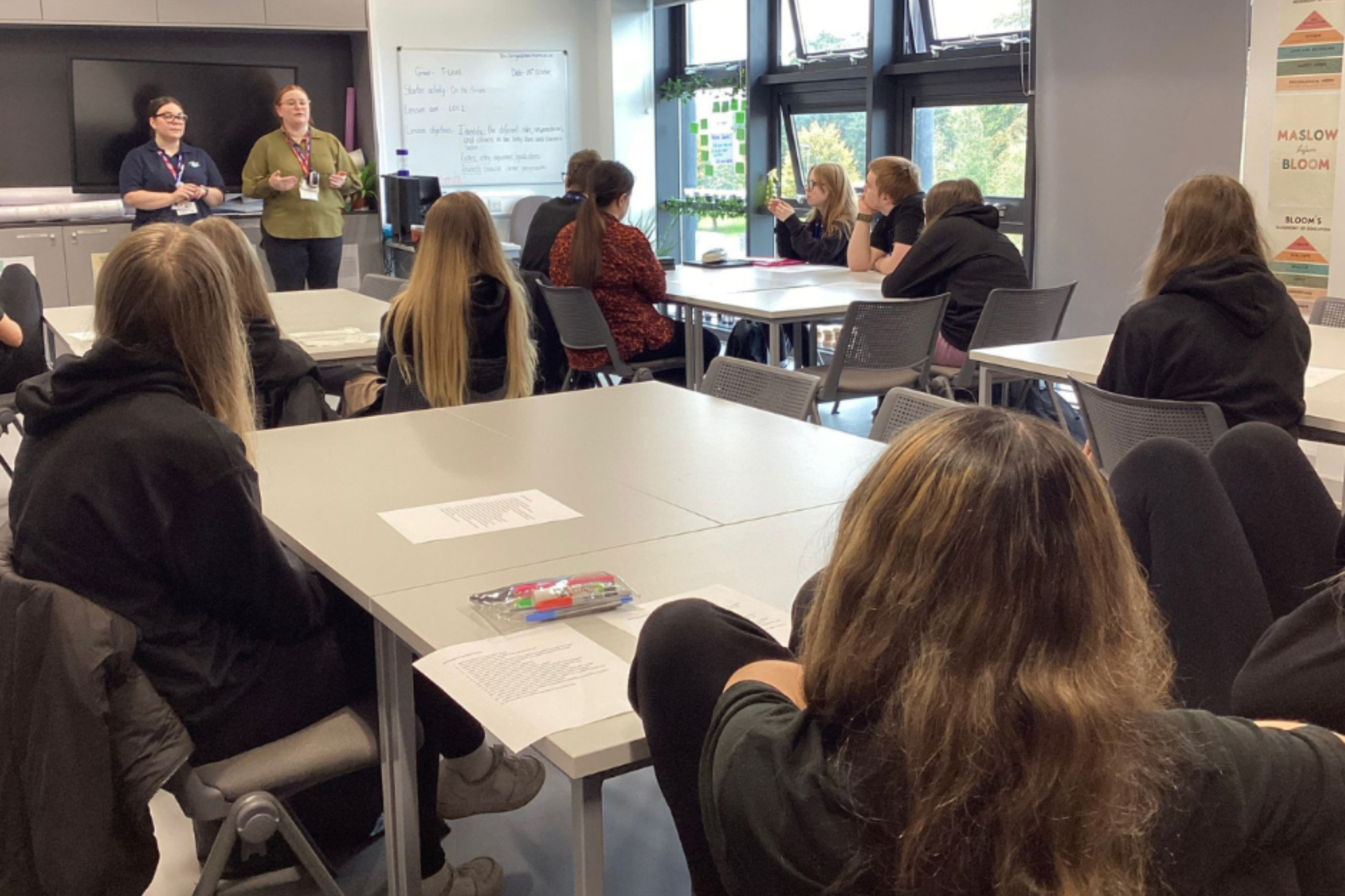 Childcare students are sitting in class, listening to a guest speaker from Kids Planet Nursey.