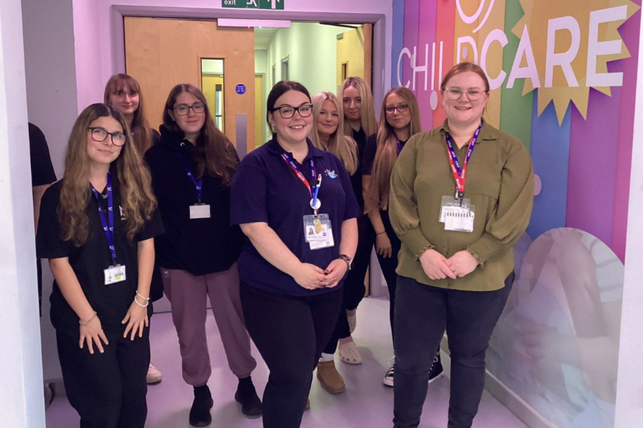 A group of Childcare students and two representatives from Kids Planet Nursey smiling for a photo.