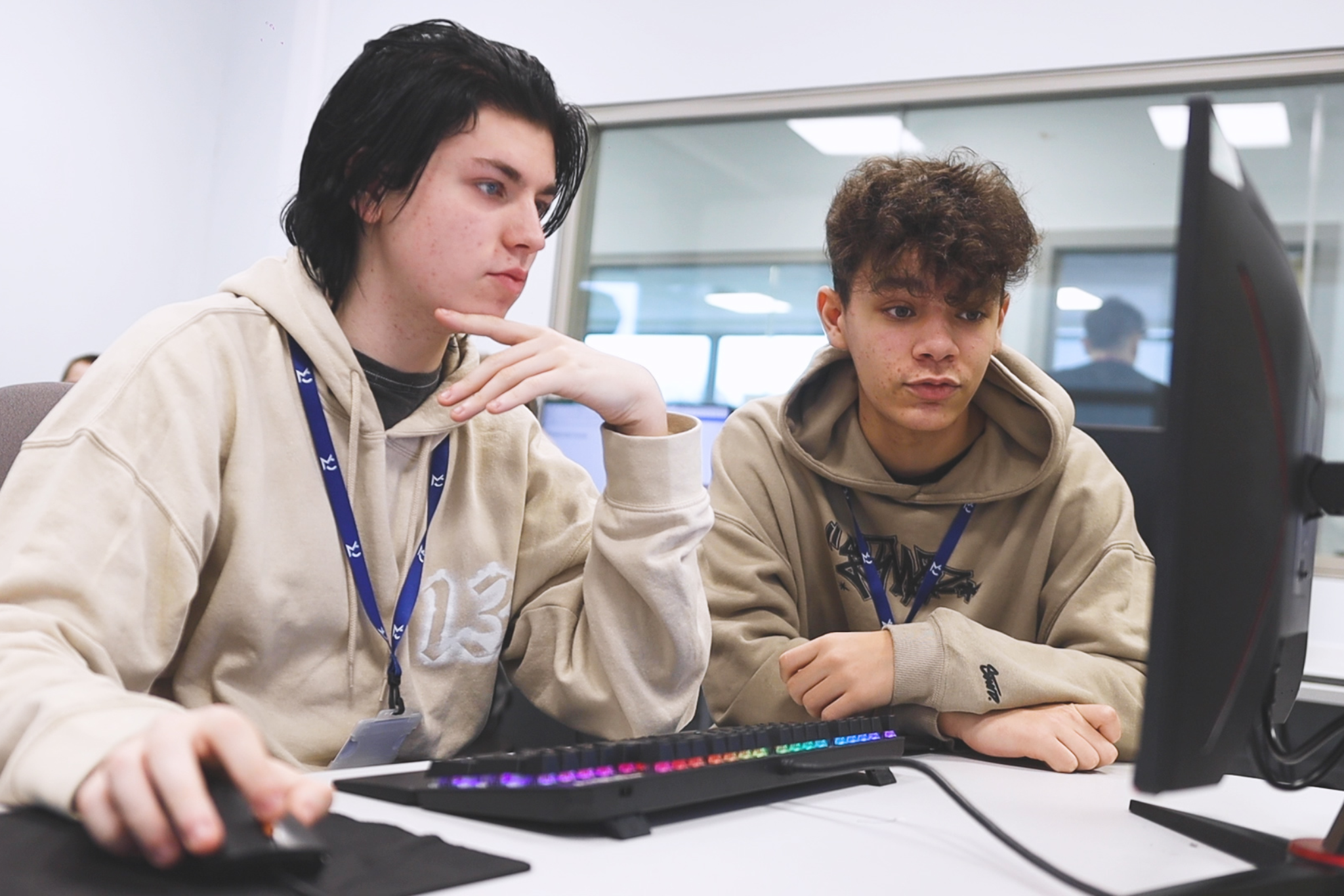 Two computing students are looking at computer and working together.