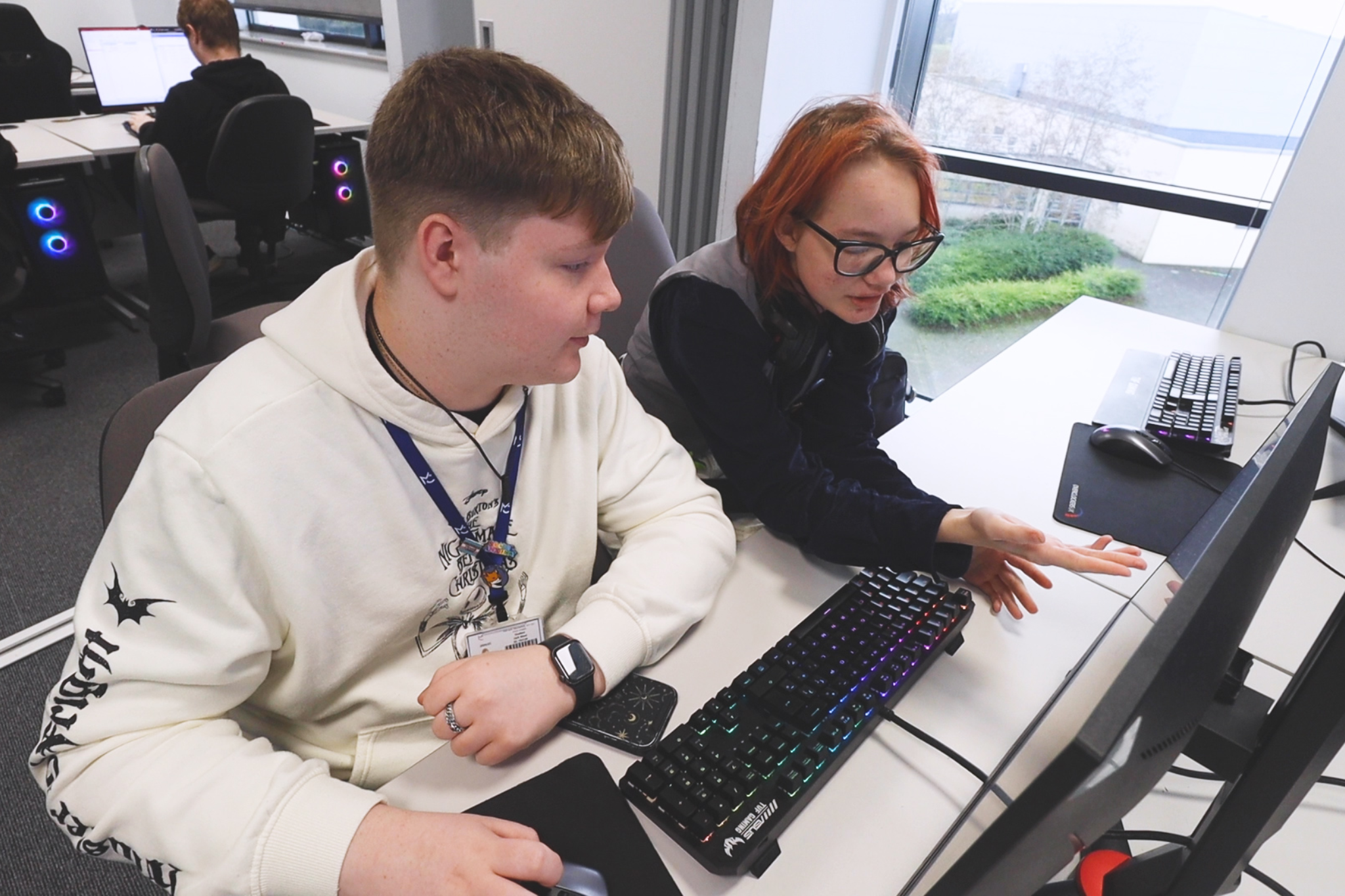 Two Computing students are working on computers.