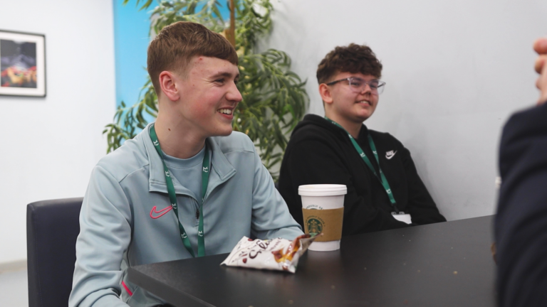 two male students sitting at a lunch table
