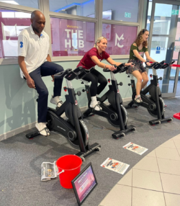 two staff members and one student riding spin bikes