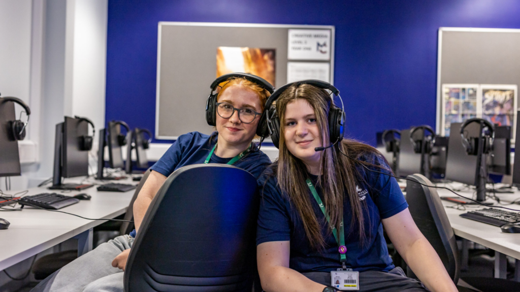 two female students wearing headphones, smiling
