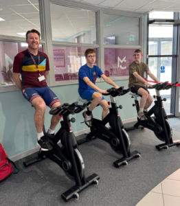 a staff member and a student riding spin bikes