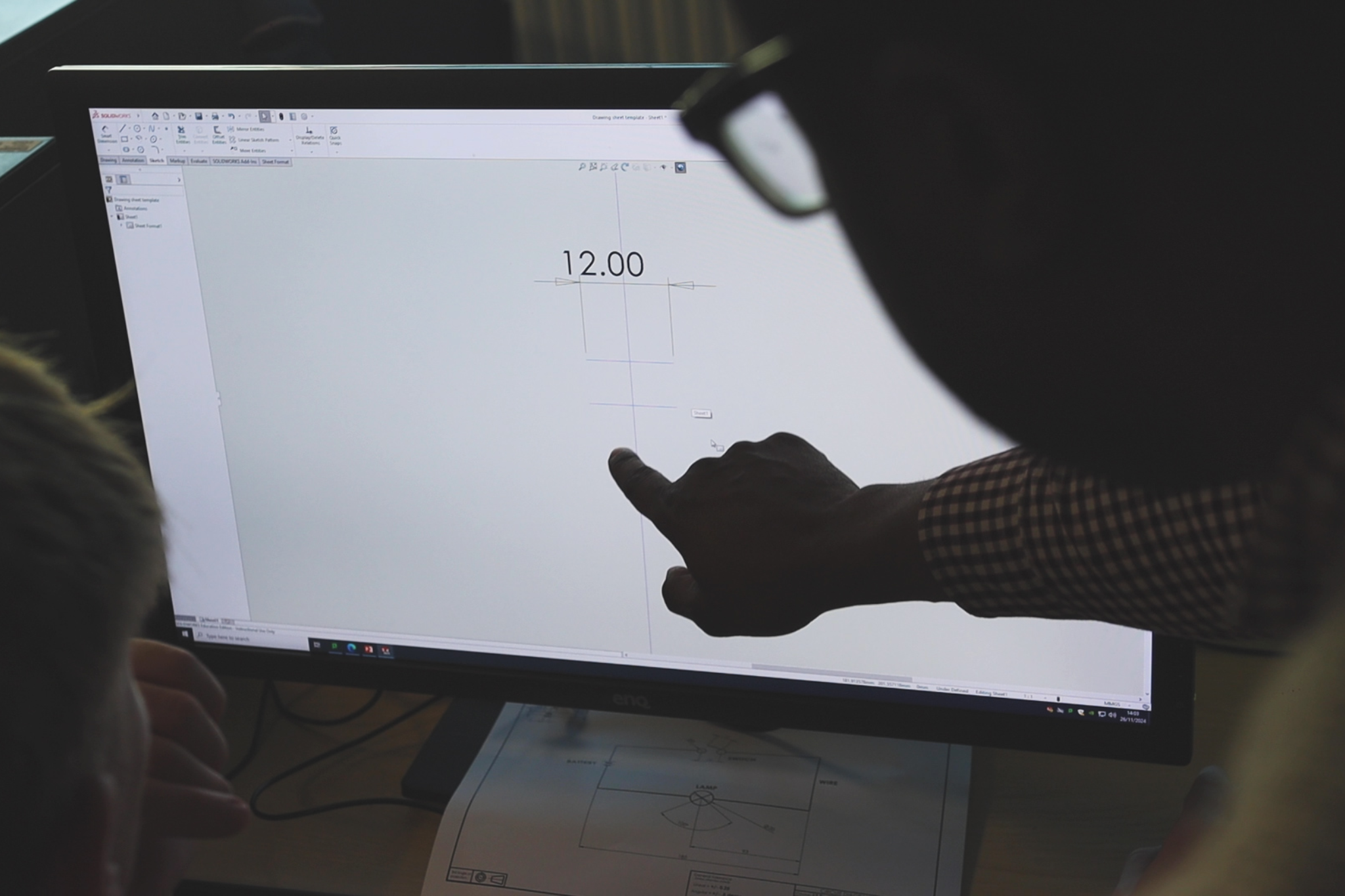 An Engineering teacher is showing a students CAD design software.