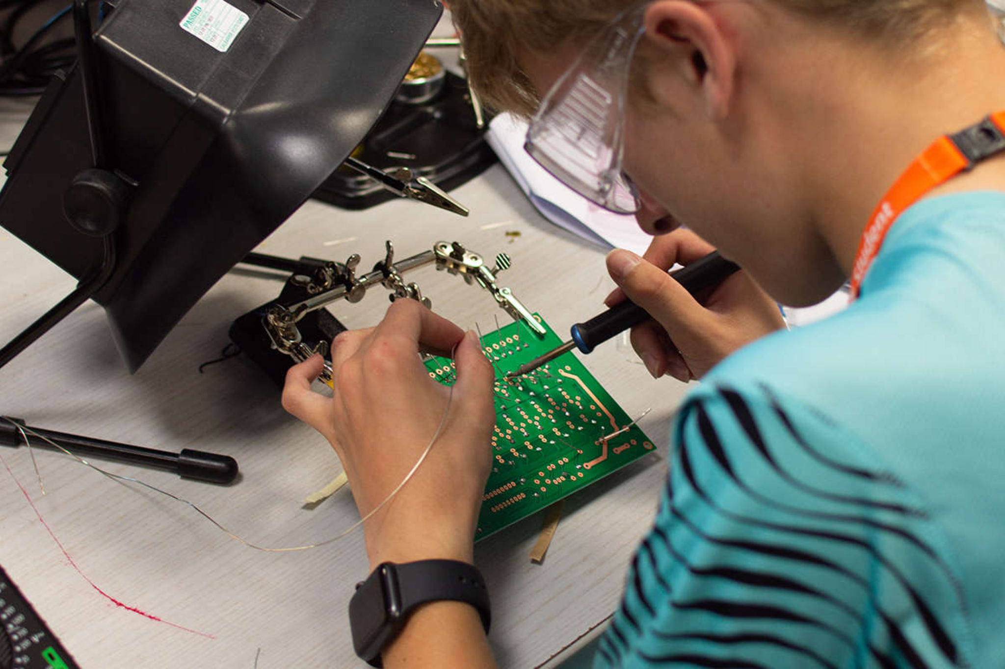 An engineering student soldering a PCB