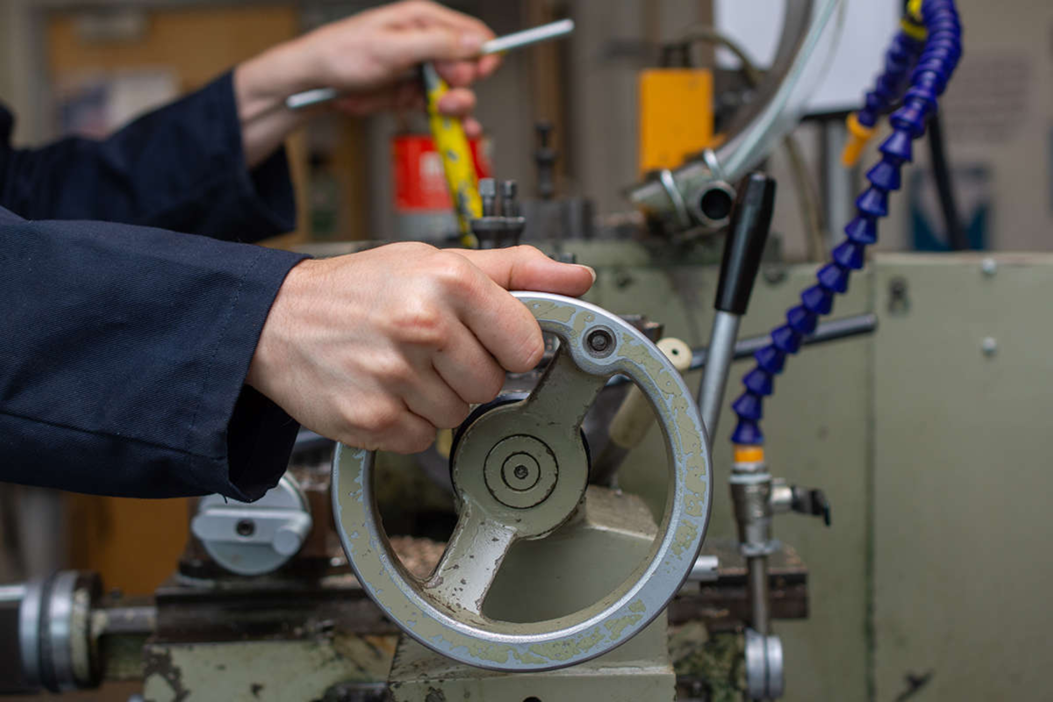 An engineering student operating a metal lathe