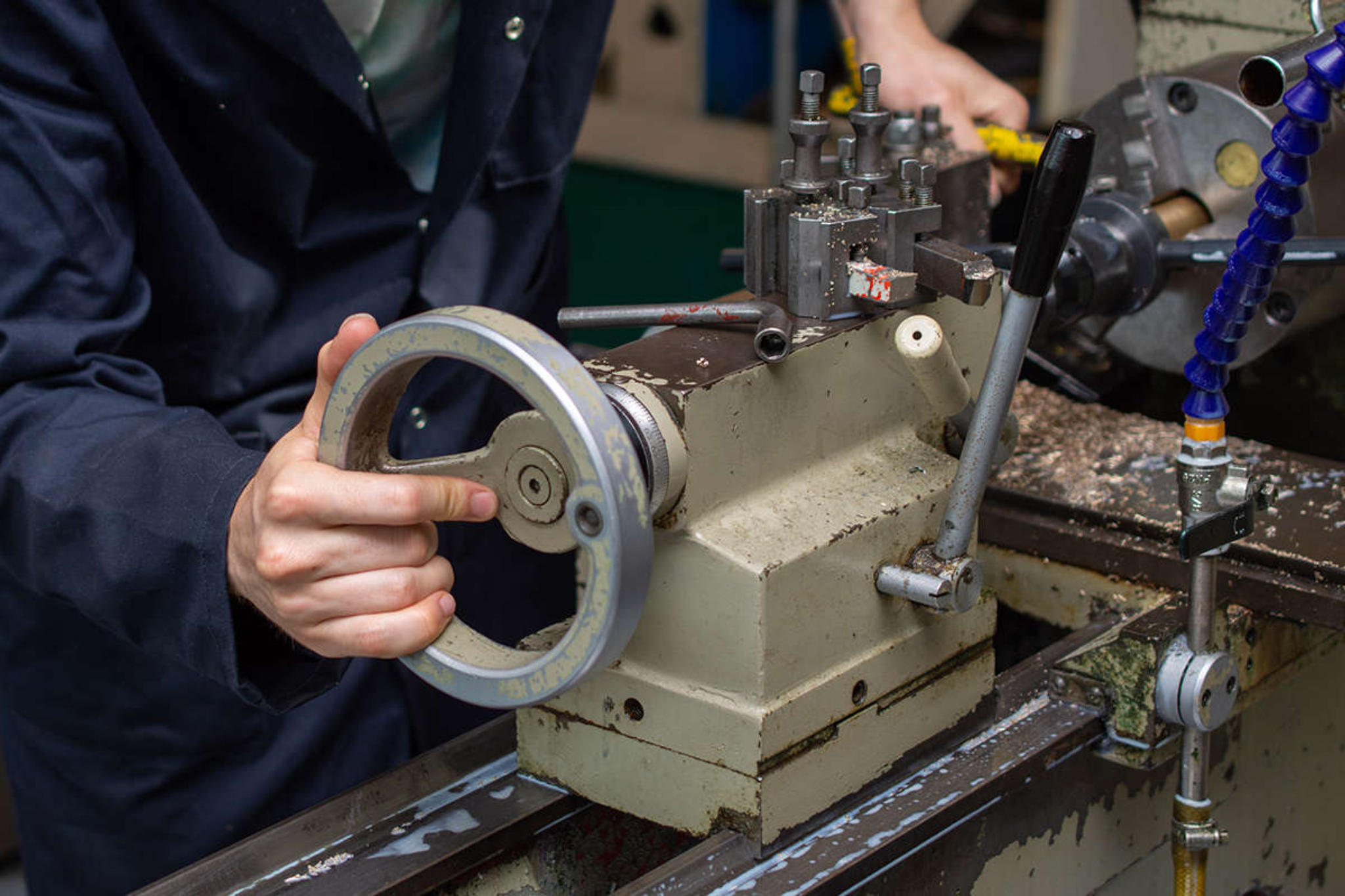 An engineering student operating a metal lathe