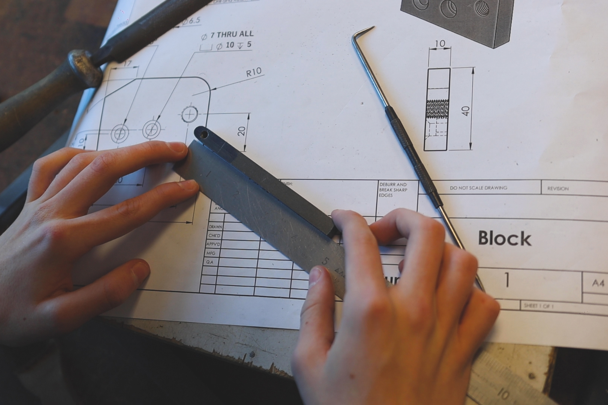 An Engineering student is measuring metal.