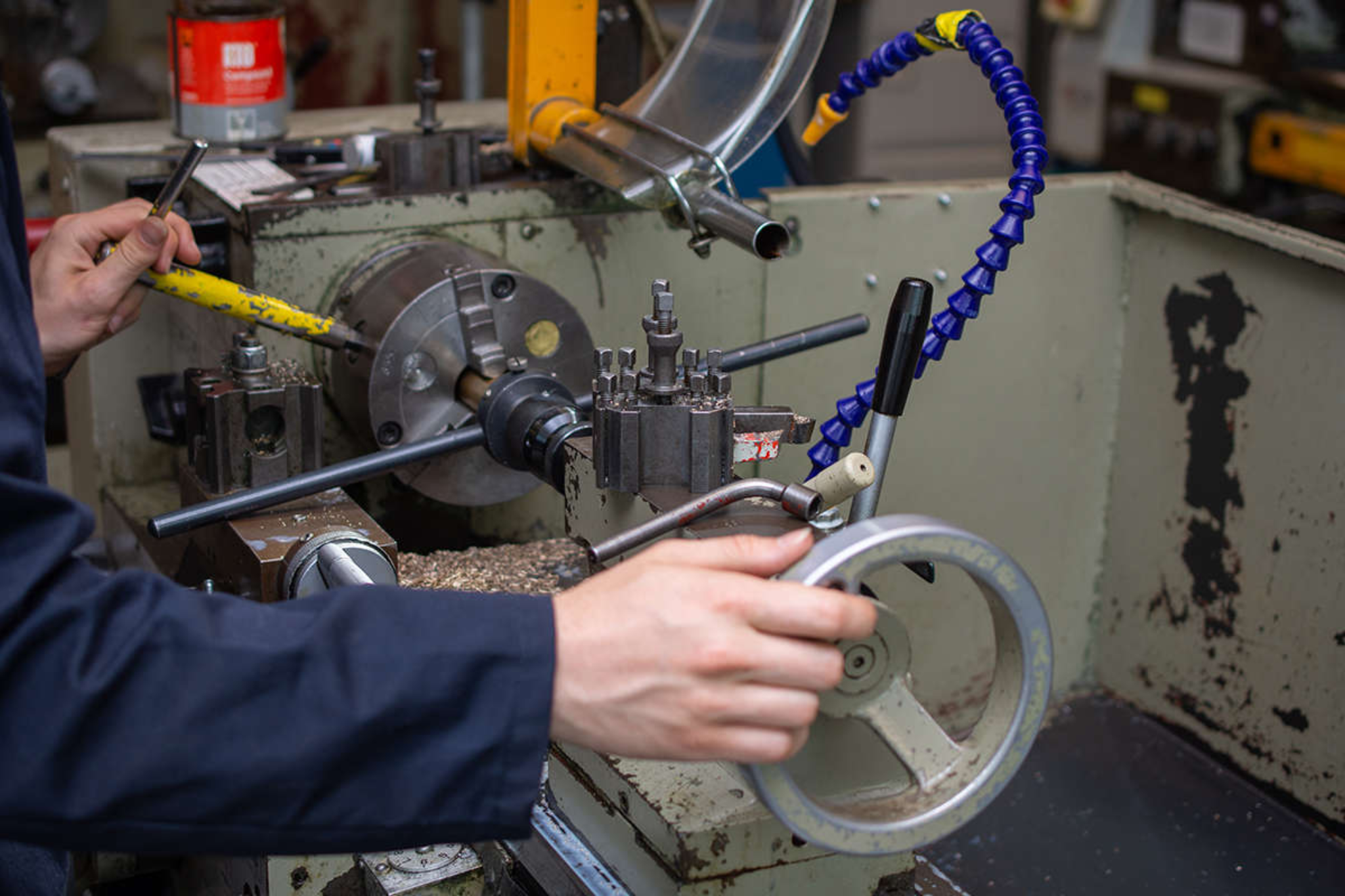 An engineering student operating a metal lathe