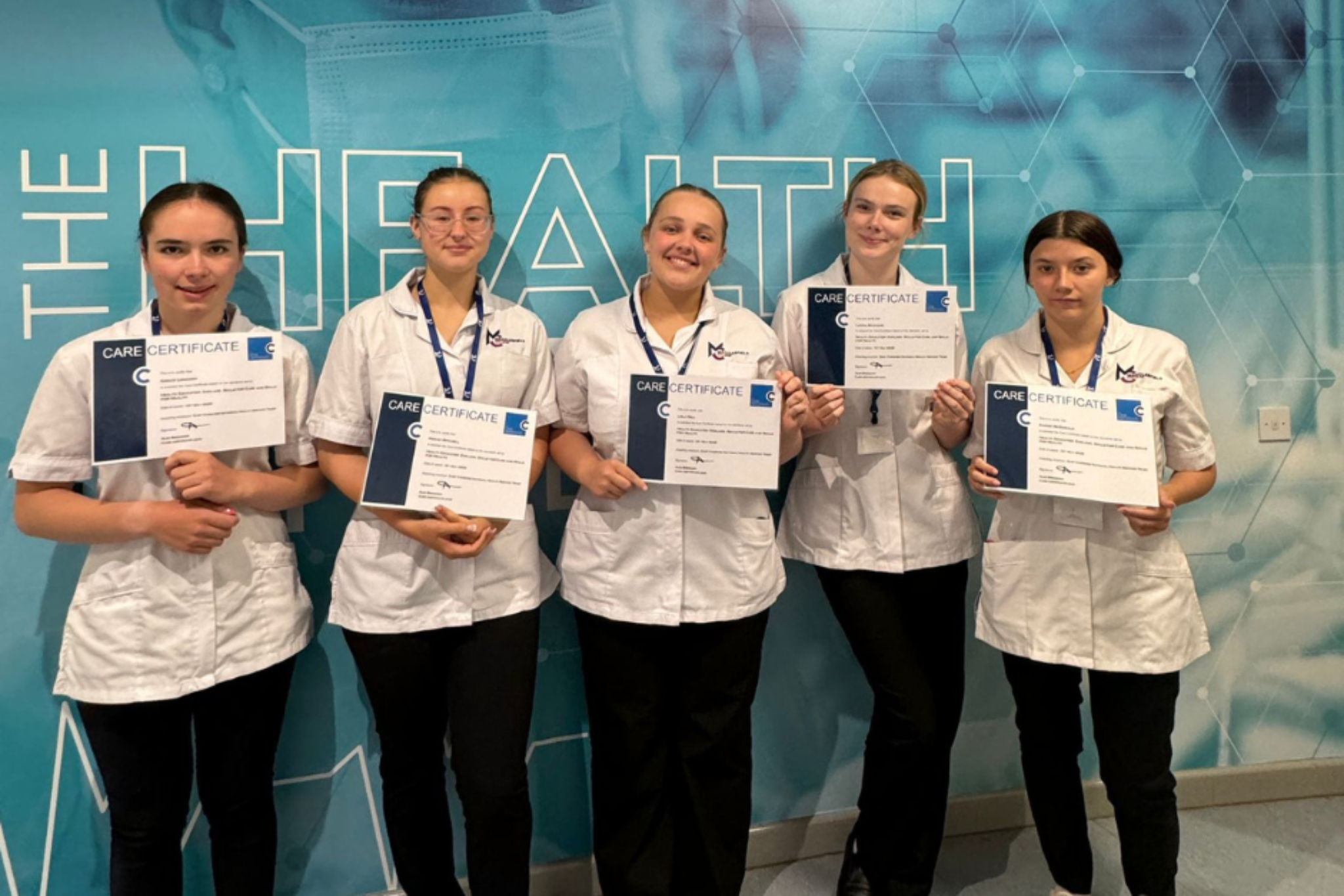 group of health and social students are smiling for a photo while holding certificates.